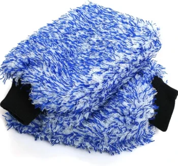 Blue fluffy cleaning mitt with black cuffs, used for washing or exfoliating skin.