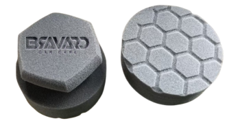 Two round foam car-care pads, one with a hex honeycomb top and the other showing branding on its surface.
